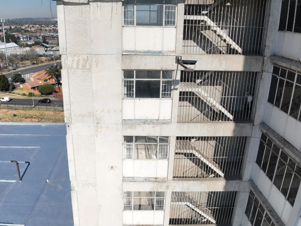 High-rise façade, wide to zoomed on a structural crack